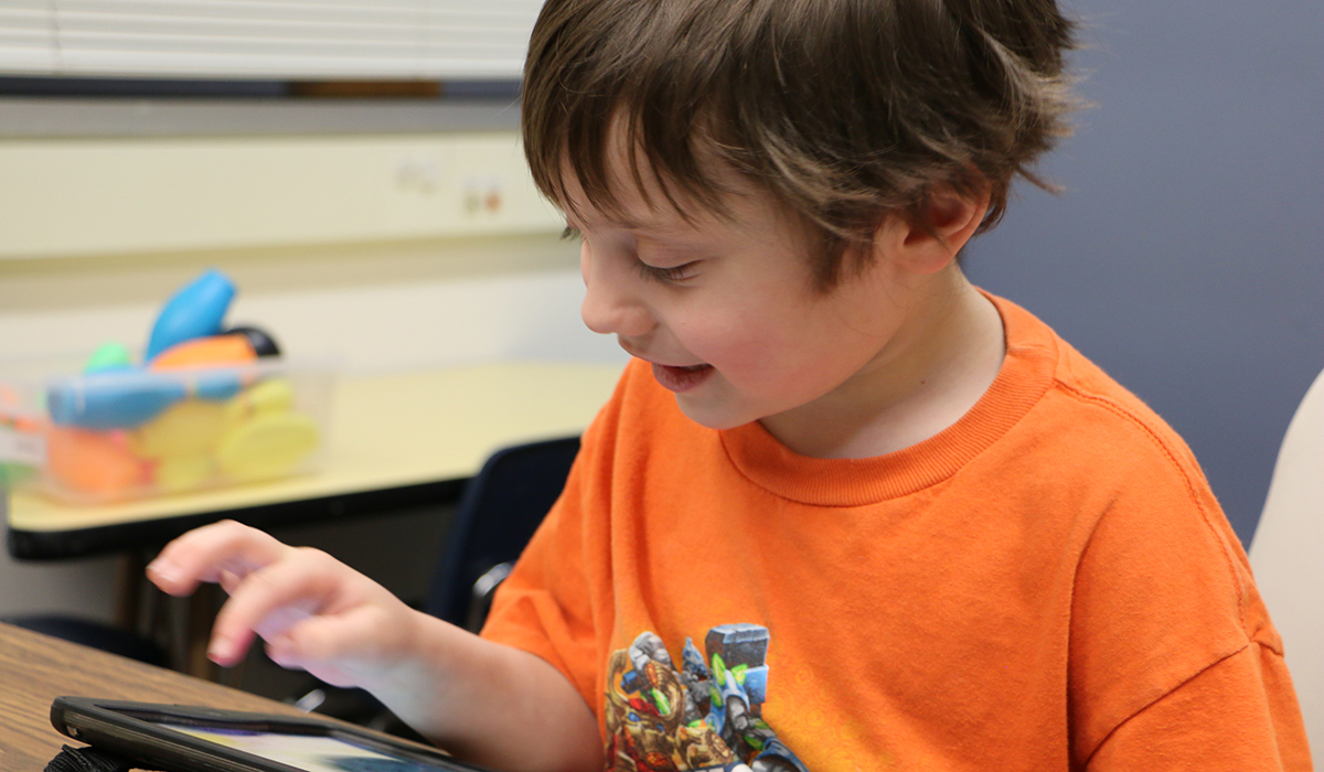 Luke Holzem works with his communication device