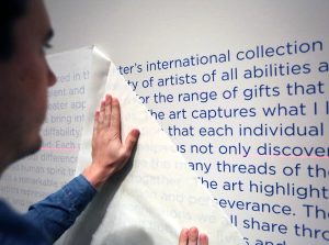 The description of the Stevens Art Collection being put on the wall of the Chazen in 2018